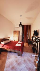 una camera con un grande letto rosso e una scrivania di Home Sweet Home COSENZA a Cosenza