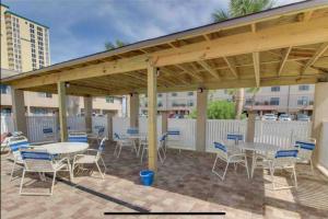 een patio met tafels en stoelen onder een paviljoen bij Emerald Shores: Steps from the Gulf, Navarre Beach in Navarre