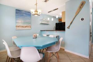 een eetkamer met een blauwe tafel en witte stoelen bij Emerald Shores: Steps from the Gulf, Navarre Beach in Navarre