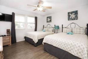 een slaapkamer met twee bedden en een plafondventilator bij Emerald Shores: Steps from the Gulf, Navarre Beach in Navarre +38 foto's