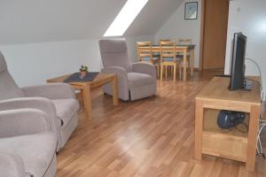 uma sala de estar com um sofá, uma televisão e uma mesa em Haus Simone em Insel Poel