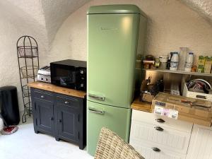 um frigorífico verde numa cozinha com um balcão em duplex vieille ville, à partager avec 2 chats em Briançon