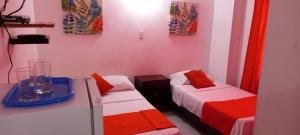Zimmer mit 2 Betten mit roter und weißer Bettwäsche in der Unterkunft Habitación I frente a la playa ( Bocagrande ) in Cartagena de Indias