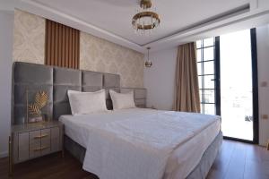 a bedroom with a large bed and a chandelier at Dar Khouadja maison d’hôtes in Mahdia