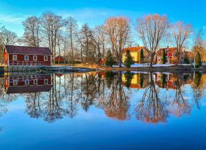 a reflection of a red house in a body of water at Bergsmansgårdens Gästhus in Asphyttan