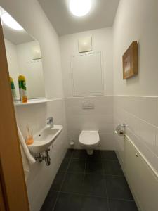 a white bathroom with a sink and a toilet at Lovely 3 Bedroom Apartment, Ski in/Ski out in Obertauern