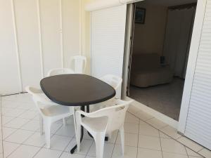 a black table and white chairs in a room at Studio au Port Dienville in Dienville +5 photos