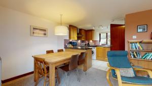 a kitchen with a wooden dining room table and chairs at Saddle Cottage in Penzance