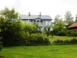 a blue house on a hill with a yard at Wallinshuset in Sunne