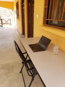 a laptop computer sitting on a table with a chair at Bella Breeze2 -Diani Beach Kenya in Diani Beach