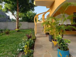 une maison avec un escalier et des plantes dans une cour dans l'établissement Bella Breeze2 -Diani Beach Kenya, à Diani Beach