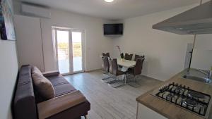 a kitchen and living room with a couch and a table at Apartmani Juresko Mrljane in Mrljane
