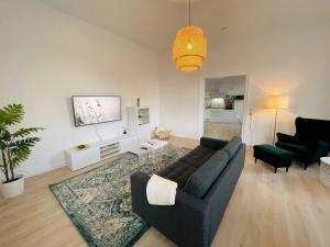 uma sala de estar com um sofá e uma mesa em YourFavoriteBed 90m2 Designwohnung im Zentrum 1 em Zwickau