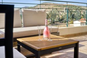 a champagne bottle and two glasses on a table at Sea & Mountain Apartment Close to Port and City in Lávrion