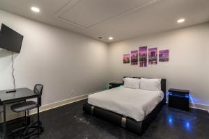 a bedroom with a bed and a desk and a tv at Amazing downtown location for groups! in Little Rock