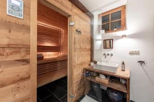 a bathroom with a sink and a wooden wall at Haus Sophie in Longostagno