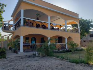 a house with a balcony with people on it at Bella Breeze2 -Diani Beach Kenya in Diani Beach