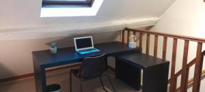 ordenador portátil en un escritorio en una habitación en Jolie maison avec jardin clos - Fontainebleau Héricy, 40 min Paris, en Héricy