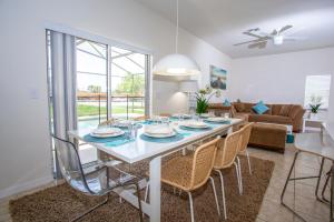 a dining room with a white table and chairs at Four Bedrooms Townhouse 4563 in Kissimmee