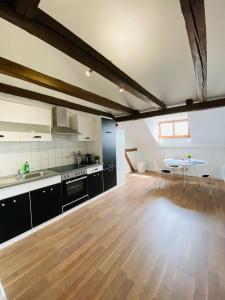 a large kitchen with a wooden floor and a table at YourFavoriteBed 80m2 Designwohnung im Zentrum 2 in Zwickau