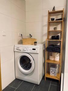eine Waschmaschine in einer Waschküche mit Regal in der Unterkunft YourFavoriteBed 80m2 Designwohnung im Zentrum 2 in Zwickau