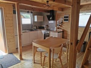 a kitchen with a table and chairs in a cabin at Zbychówko in Zbychowo