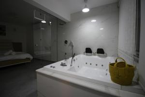ein Badezimmer mit einer Badewanne mit 2 Stühlen und einem Waschbecken in der Unterkunft סוויטות נופי החרמון - Hermon View Suites in Madschdal Schams