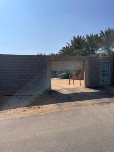 a brick building with a garage in a field at مزرعة السلطانية in Buraydah