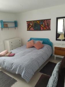 1 dormitorio con 1 cama y una pintura en la pared en Casa Lola, en Barra de Valizas