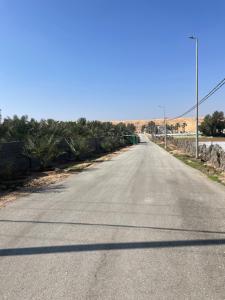 an empty road in the middle of the desert at مزرعة السلطانية in Buraydah