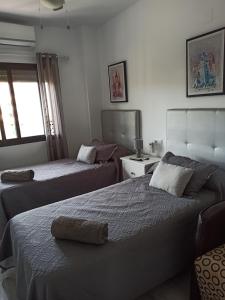 Una habitación de hotel con dos camas y una ventana. en Playa Atlanterra, 1ª linea playa vistas al mar, en Zahara de los Atunes 67 fotos más