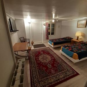 ein Wohnzimmer mit 2 Betten und einem Teppich in der Unterkunft Chambres d'hôtes GOBILLON in Maintenon