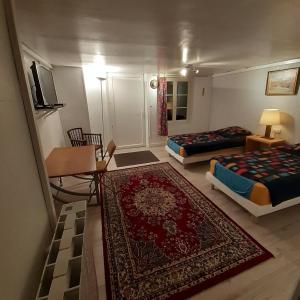 a living room with two beds and a rug at Chambres d'hôtes GOBILLON in Maintenon