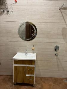 a bathroom with a sink and a mirror at Hotel Sukoon Bharatgarh in Rūpnagar