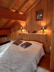 - une chambre avec un lit dans une pièce dotée de murs en bois dans l'établissement Chalet de campagne, à Sancey-le-Long