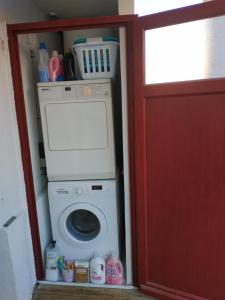 - un lave-linge dans une chambre dotée d'une porte rouge dans l'établissement Port love, à Port-Vendres