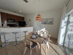 a kitchen and dining room with a table and chairs at Four Bedroom w/ Screened Pool Close to Disney 4572 in Kissimmee