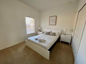 a white bedroom with a bed and a window at Four Bedroom w/ Screened Pool Close to Disney 4572 in Kissimmee