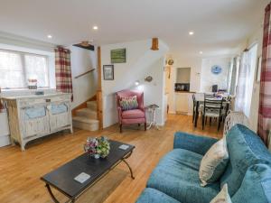 uma sala de estar com um sofá azul e uma mesa em Happy Landing em Harlech