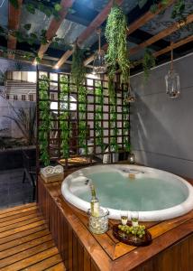 baño con bañera grande con plantas en la pared en Grand Cinema & Jacuzzi Appartment, en Ciudad de México