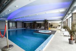 a large swimming pool with a blue ceiling at Apartman La Foresta Kopaonik in Kopaonik