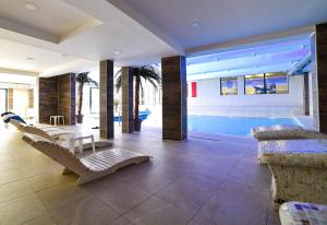a living room with a pool and some chairs at Apartman La Foresta Kopaonik in Kopaonik