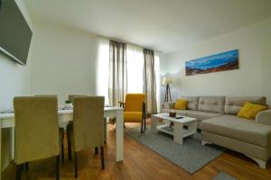 a living room with a couch and a table at Apartman La Foresta Kopaonik in Kopaonik