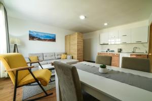 a kitchen and living room with a table and chairs at Apartman La Foresta Kopaonik in Kopaonik