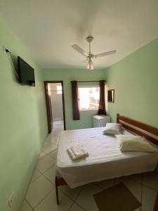 a bedroom with a bed and a ceiling fan at Hotel Modelo in Poços de Caldas