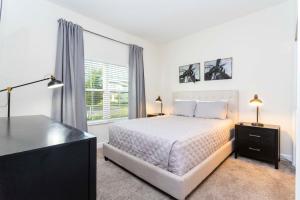 Habitación blanca con cama y ventana en Magnificent 5Bd w/ Pool Close to Disney @Storey Lake 4800, en Kissimmee