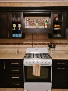 a white stove in a kitchen with black cabinets at LUNA APARTMENT in Puerto Peñasco