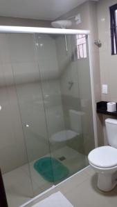 y baño con ducha de cristal y aseo. en Apartamento na Praia de Ponta Negra, en Natal