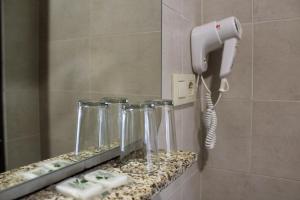 a bathroom with a hair dryer and four glasses at Hostal Madrid in Toledo