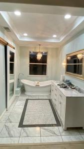 a white bathroom with a tub and a sink at Beautiful peaceful desirable home in Madera Rancho in Madera
